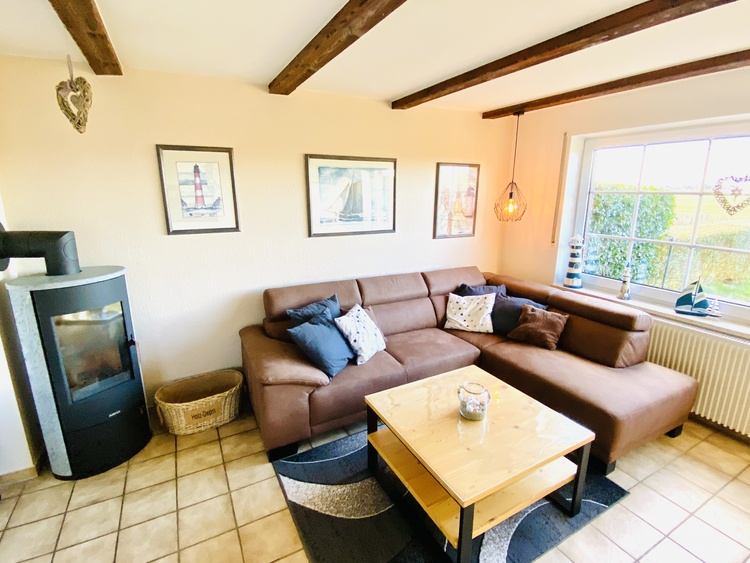 Blick in den Wohnbereich mit Ecksofa und Kamin
