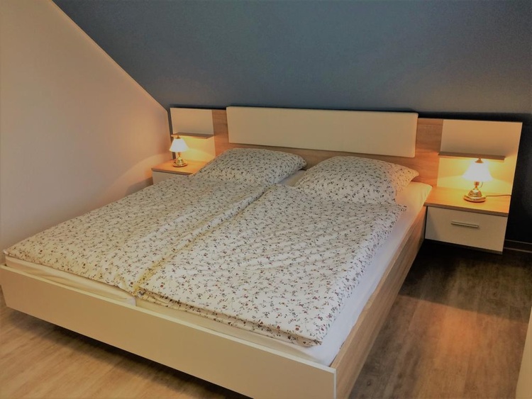 Schlafzimmer mit Doppelbett und großem Kleiderschrank
