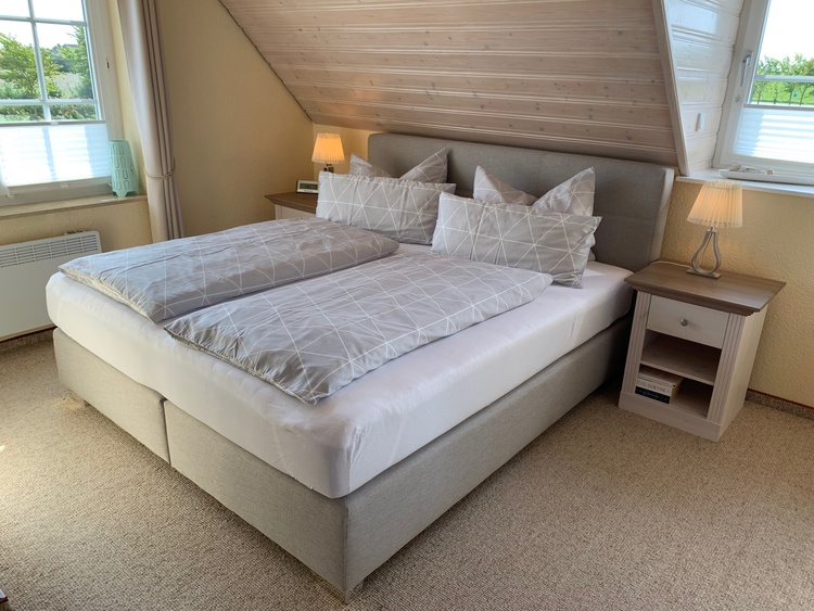 Sonniges Schlafzimmer mit hochwertigem Bosspringbett.